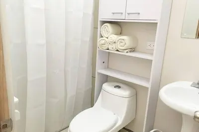 a white bathroom with a toilet and a sink at Conveniente ubicación en zona muy silenciosa Apt 3 in Curridabat