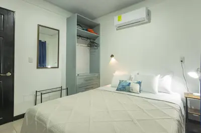 a bedroom with a large white bed and a mirror at Casa Serenity Arenal,Fully Equip in Fortuna