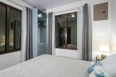 a white bedroom with a bed and a window at Casa Serenity Arenal,Fully Equip in Fortuna