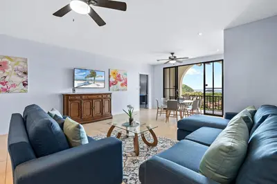 a living room with blue couches and a table at Coco Top-Floor 3-BD Ocean-View Unit at Pacifico By SPCR in Coco