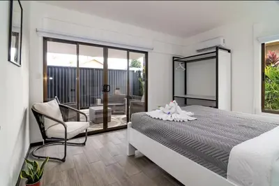 a bedroom with a bed and a chair and a balcony at Volcano Lux Arenal in Fortuna