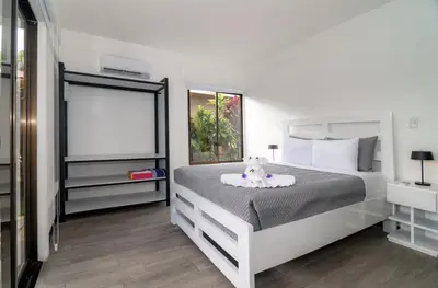 a bedroom with a large white bed and a window at Volcano Lux Arenal in Fortuna