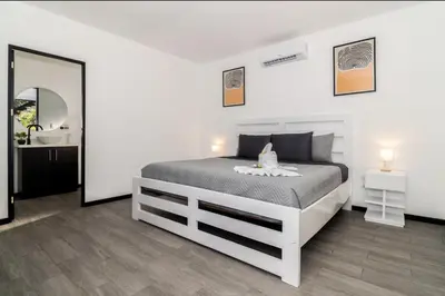 a bedroom with a bed and a sink and a mirror at Volcano Lux Arenal in Fortuna