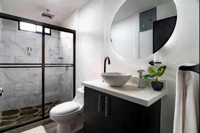 a bathroom with a sink and a toilet and a mirror at Volcano Lux Arenal in Fortuna