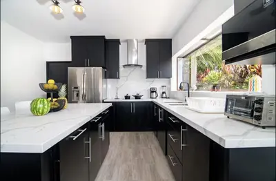 a kitchen with black and white cabinets and a sink at Volcano Lux Arenal in Fortuna