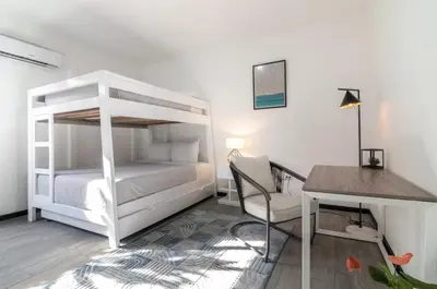 a bedroom with a white bunk bed and a desk at Volcano Lux Arenal in Fortuna