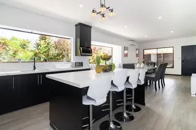 a kitchen with a large island with white counter tops at Volcano Lux Arenal in Fortuna