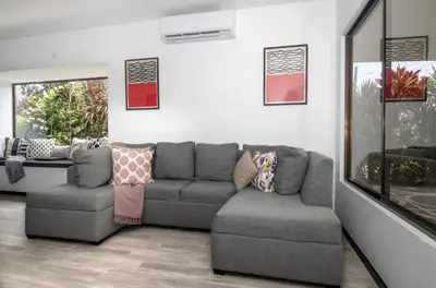 a living room with a gray couch and a chair at Volcano Lux Arenal in Fortuna