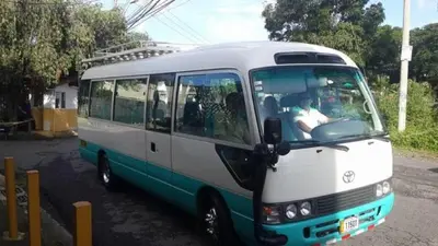 a white and blue bus parked on a street at Casa Echavarria in San José