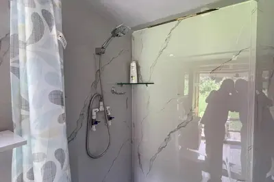 a person taking a picture of a shower in a bathroom at \u58ee\u89c2\u666f\u8272\u7684\u5b81\u9759\u6728\u5c4b in Santa Ana
