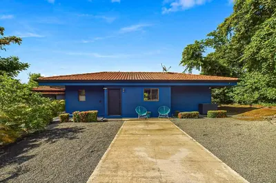 a blue house with two chairs in front of it at Casa Tranquilo 26B - Beautiful Home With A Private Pool in Playa Flamingo