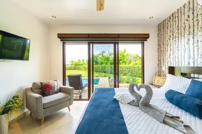 a bedroom with a bed and a couch and a chair at Casa Tranquilo 26B - Beautiful Home With A Private Pool in Playa Flamingo