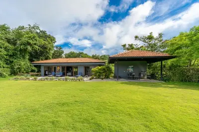 a house with a large yard in front of it at Casa Tranquilo 26B - Beautiful Home With A Private Pool in Playa Flamingo