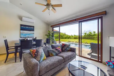 a living room with a couch and a dining room at Casa Tranquilo 26B - Beautiful Home With A Private Pool in Playa Flamingo