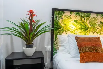 a bedroom with a bed with a plant on a table at Bukala Village Lodge in San Ramón