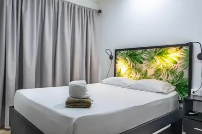 a bedroom with a bed with a large headboard at Bukala Village Lodge in San Ramón