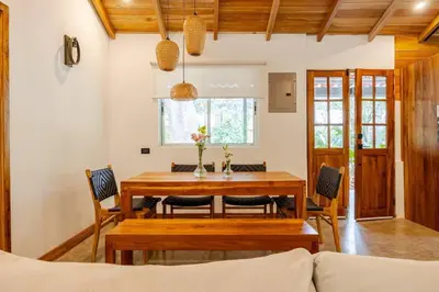 a dining room with a wooden table and chairs at Casa PlayaAzul, walk to the beach, 3 rooms in Santa Teresa Beach
