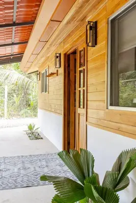 a wooden house with a plant in front of a door at Casa PlayaAzul, walk to the beach, 3 rooms in Santa Teresa Beach