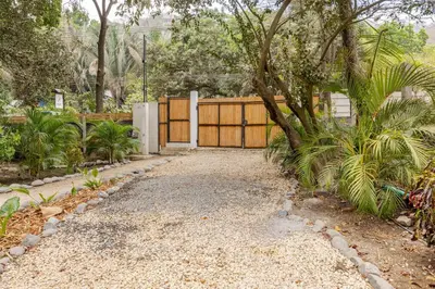 a driveway with a fence and a tree in a yard at Casa PlayaAzul, walk to the beach, 3 rooms in Santa Teresa Beach