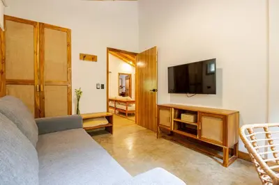 a living room with a couch and a flat screen tv at Casa PlayaAzul, walk to the beach, 3 rooms in Santa Teresa Beach