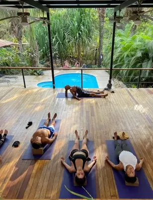 a group of people laying on mats in front of a pool at Casa PlayaAzul, walk to the beach, 3 rooms in Santa Teresa Beach