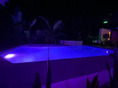 a swimming pool with purple lighting at night at Fortuna Jungle & River Retreat - Private pool, River and Wifi in the forest - Secluded, peaceful, truly UNIQUE! A GEM! Book Now! in Guayabal