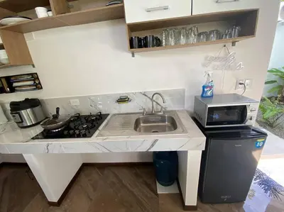 a small kitchen with a sink and a stove at Fortuna Jungle & River Retreat - Private pool, River and Wifi in the forest - Secluded, peaceful, truly UNIQUE! A GEM! Book Now! in Guayabal