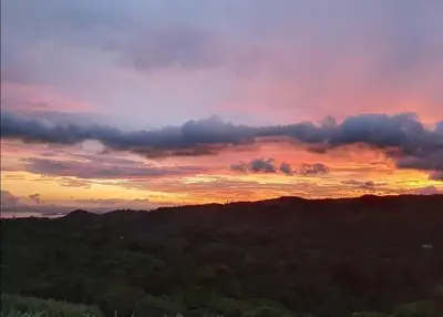 a view of a sunset from a hill with trees at Magic Place Monteverde in Monteverde Costa Rica