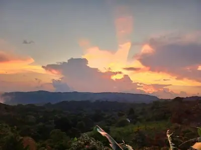 a sunset in the mountains with trees and clouds at Magic Place Monteverde in Monteverde Costa Rica