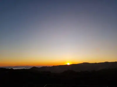 a sunset with the sun setting over the mountains at Magic Place Monteverde in Monteverde Costa Rica