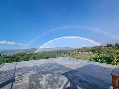 a rainbow in the sky over a patio at Magic Place Monteverde in Monteverde Costa Rica