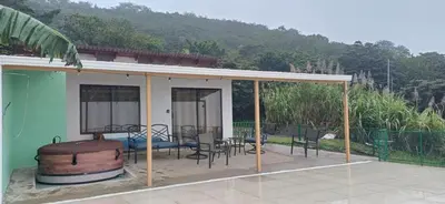 a house with a patio with a barrel and chairs at Magic Place Monteverde in Monteverde Costa Rica