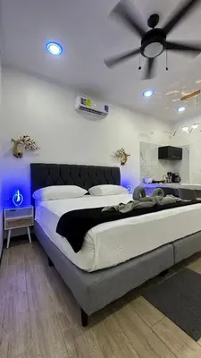 a bedroom with a large bed with blue lights at H et L in Tortuguero
