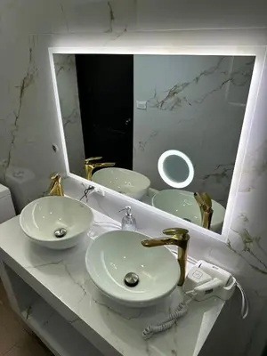 a white bathroom with a sink and a mirror at H et L in Tortuguero