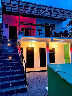 a building with stairs in front of it with lights at H et L in Tortuguero