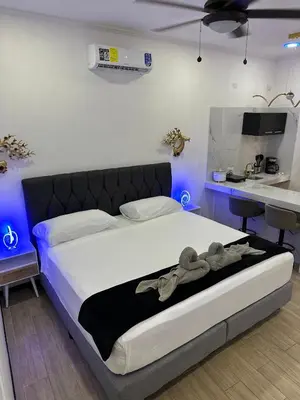 a bedroom with a large bed with a kitchen in it at H et L in Tortuguero