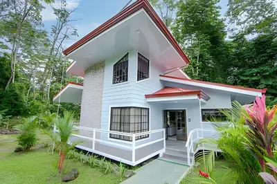a white house with a red roof at Villa Escondida La Fortuna in Fortuna