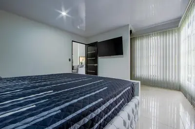 a bedroom with a bed and a flat screen tv at Villa Escondida La Fortuna in Fortuna