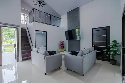 a living room with couches and a staircase at Villa Escondida La Fortuna in Fortuna