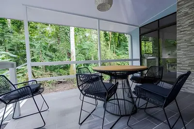 a patio with a wooden table and chairs at Villa Escondida La Fortuna in Fortuna
