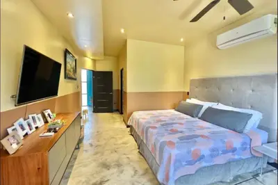 a bedroom with a bed and a flat screen tv at Villas Confort Completas Manuel Antonio Kepos Costa Ric in Quepos