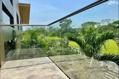 a glass balcony with a view of a garden at Villas Confort Completas Manuel Antonio Kepos Costa Ric in Quepos