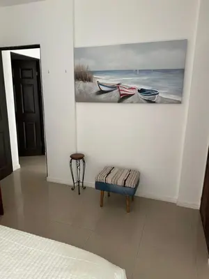 a bedroom with a painting on the wall and a bench at Villa Verde 2 Casa 14 in Tamarindo