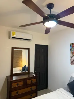 a bedroom with a ceiling fan and a dresser with a mirror at Villa Verde 2 Casa 14 in Tamarindo