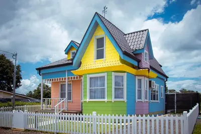a colorful house with a white fence at La Fortuna Up House in Fortuna