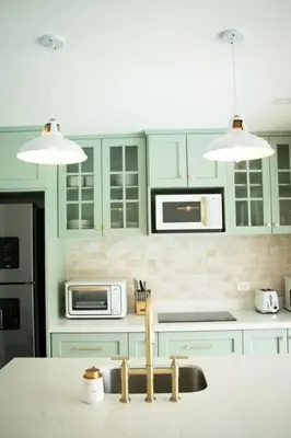 a kitchen with green cabinets and a white counter top at La Fortuna Up House in Fortuna