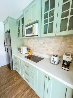 a kitchen with green cabinets and a white counter top at La Fortuna Up House in Fortuna