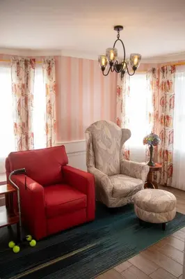 a living room with a red chair and a chair at La Fortuna Up House in Fortuna