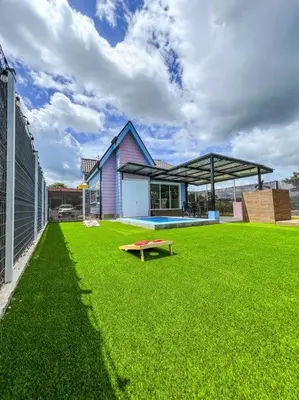 a green yard with a bench in front of a building at La Fortuna Up House in Fortuna