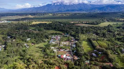 an aerial view of a village with mountains in the background at Habitaciones Kolibri in Quepos